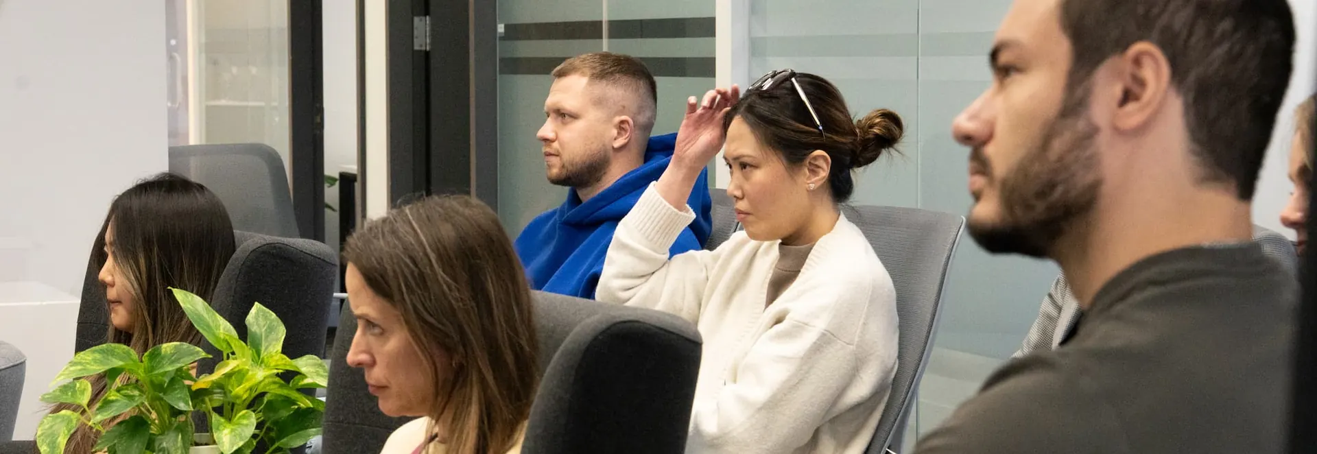 A team seated together listening to a presentation in the office